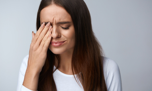 Woman experiencing eye pain 