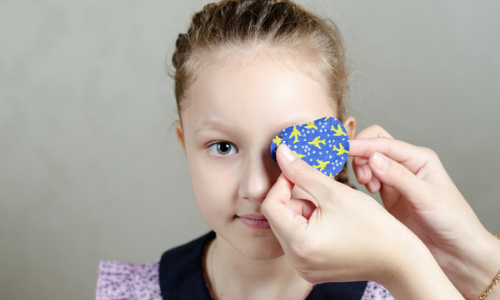 Little girl having patch placed over eye 