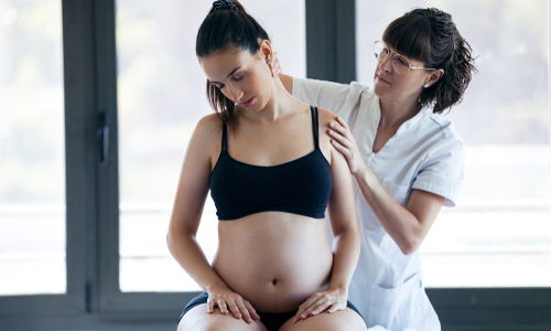 Pregnant woman receiving neck treatment