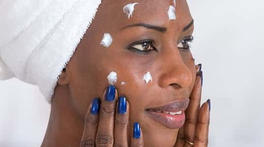 Image of a woman applying face moisturizer. 