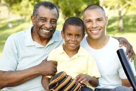 Image of a grandfather, son and grandson with baseball bat and glove. 