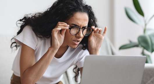 Image of an elderly woman wearing glasses and reading a book.