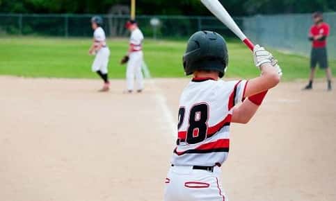 Kid batting on baseball field