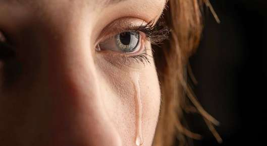 Close up image of a closed eye tearing.