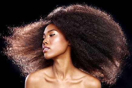 Image of an ethnic woman shaking her long, curly hair.