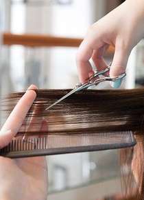 Image of hands trimming long hair.