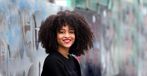 Image of woman with curly hair smiling.