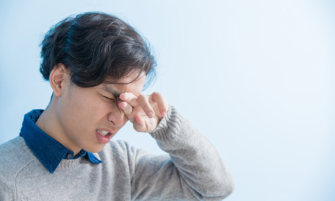 Man rubbing irritated eyes