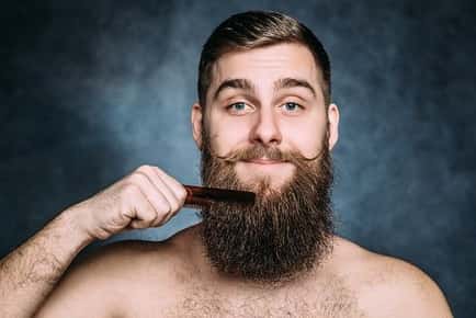 Image of man combing his long beard.