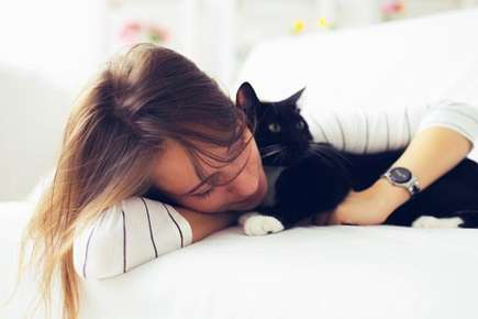 image of a lady cuddling a cat. 