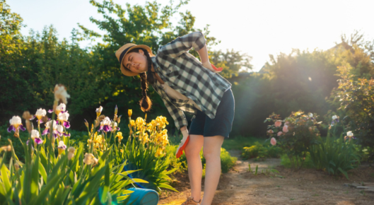 Young woman feels back pain while gardening.