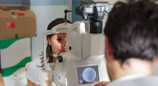 Image of an optometrist using an eye examination machine.