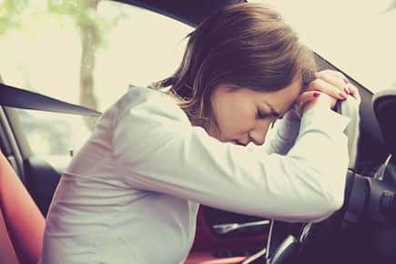 Image of a stressed out woman in her car. 