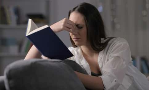 Woman struggling to read book