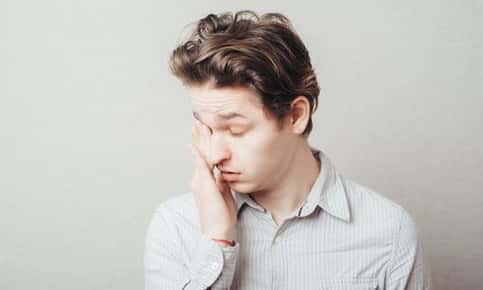 Image of a man rubbing his itchy eyes. 
