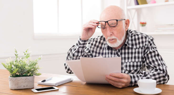 Old man struggles to read.