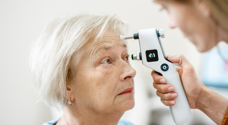 Eye doctor using tonometer on patient