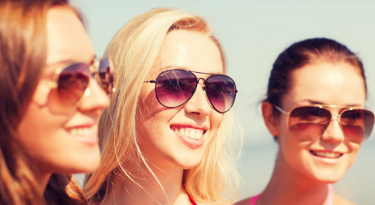 Women wearing sunglasses on the beach.