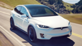 Tesla Model X white color electric SUV on road