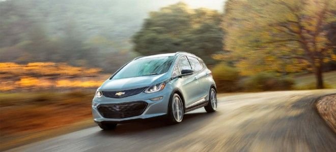a chevy bolt driving on a country road