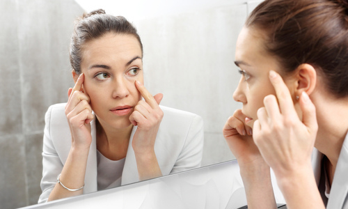 Woman looking at eyes in mirror