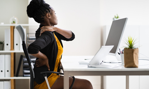 Woman having back pain at work