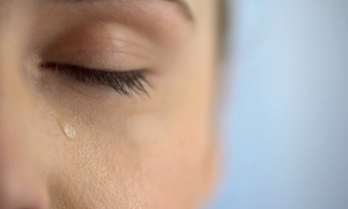 Woman with tear falling from her eyes