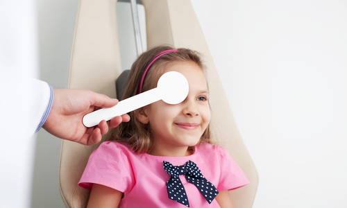 Little girl getting an eye exam at the optometrist 