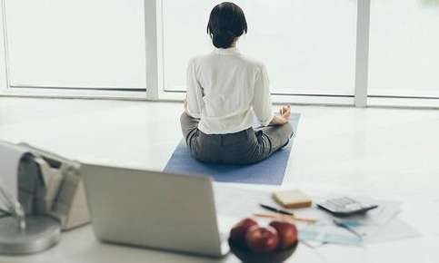 Woman practicing yoga in office