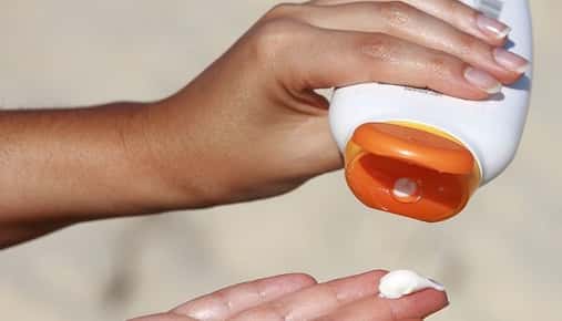 Image of sunscreen being squeezed into a hand.