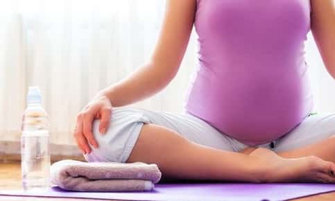 Woman practicing yoga while pregnant