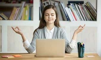 Woman uses mindfulness to focus on computer