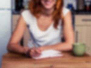 blurry image of smiling woman sitting at table