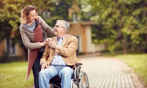 Woman caregiving for man in a wheelchair