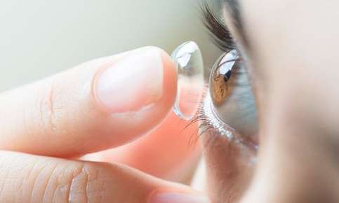 Woman applying contact lens