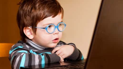 boy with glasses on laptop