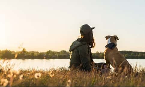 Woman at lake with dog during summer