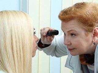 eye care professional examining woman's eyes