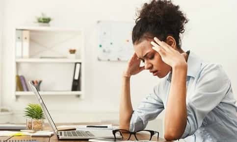 Woman experiencing a headache at work