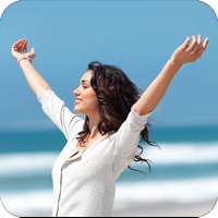 image of woman on the beach raising her arms