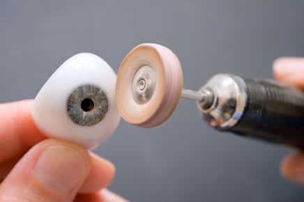 Image of a prosthetic eye being cleaned. 