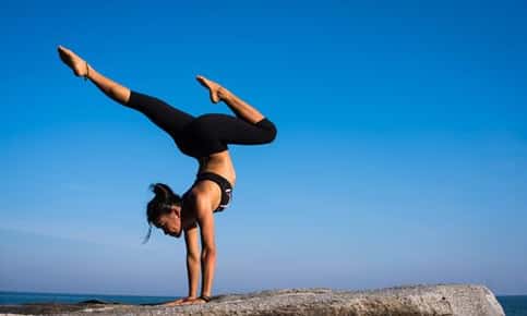 Image of a woman doing handstand. 