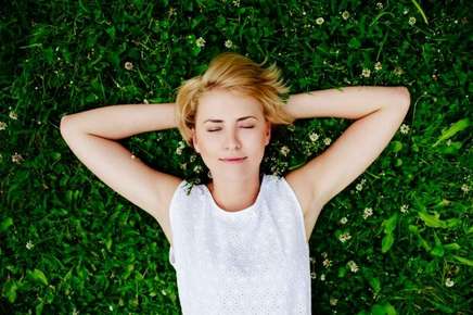 image of relaxed woman laying in the grass