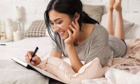 Woman journaling in bed