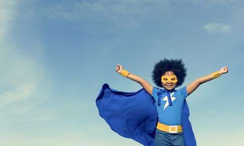 Image of a confident young boy dressed as a super hero. 