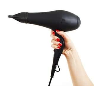 Image of a hand holding a hair dryer. 