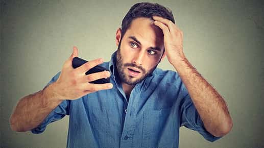 Image of a concerned man holding his head.