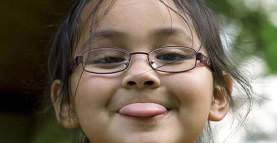 Image of girl wearing glasses and sticking tongue out. 