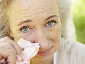 Image of an elderly woman holding a tissue.