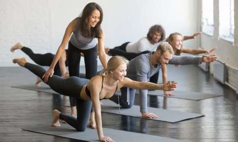 Female yoga instructor teaching bird pose